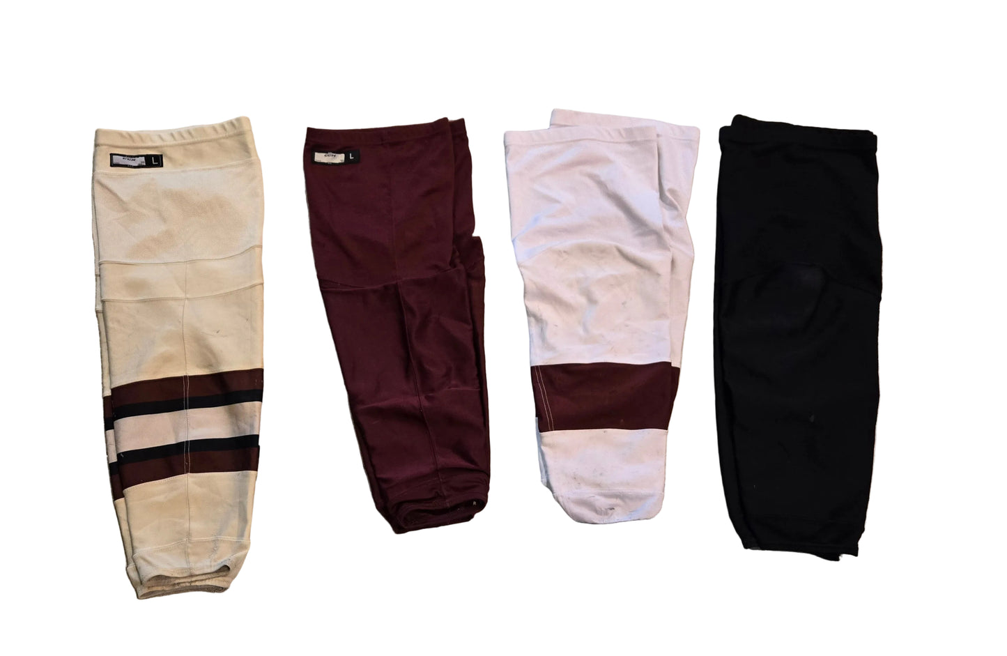 Four pairs of hockey socks, shown in cream, maroon, white and solid black.