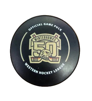Hockey puck with Portland Winterhawks and '50th Anniversary' branding on a wooden surface